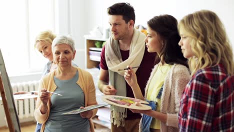 group-of-artists-discussing-painting-at-art-school