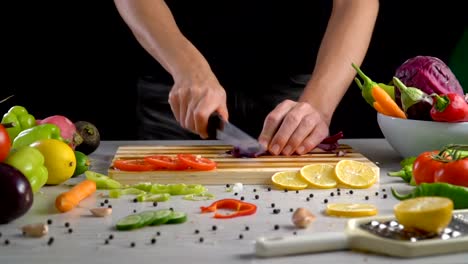 Man-is-cutting-vegetables-in-the-kitchen,-slicing-red-cabbage-in-slow-motion