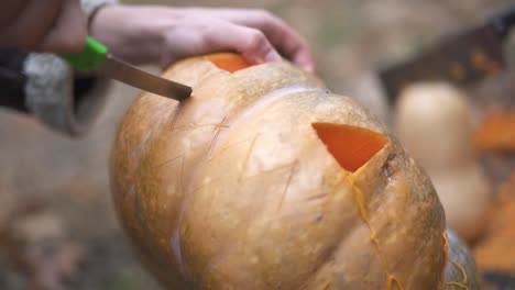 Halloween.-Männliche-Hände-schnitzen-einen-Halloweenkürbis.