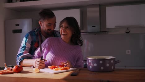 Smiling-girlfriend-threatening-her-boyfriend-with-knife-in-the-kitchen