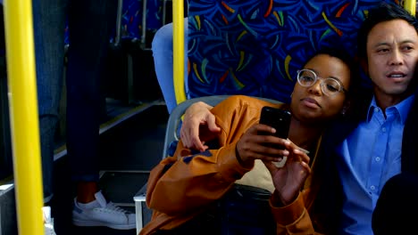 Couple-using-mobile-phone-while-travelling-in-bus-4k