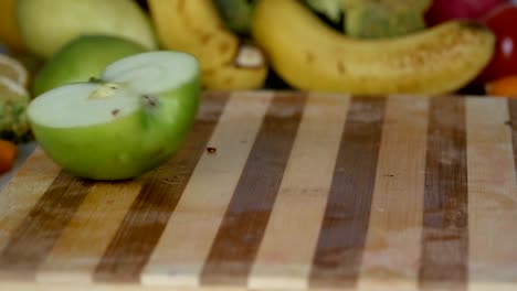 Rebanadas-de-la-manzana-caída-en-tabla-de-cortar-en-cámara-lenta