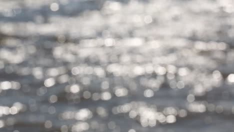 Mesmerizing-bright-defocused-glares-from-the-sun-on-the-wavy-surface-of-the-water