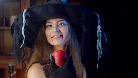 Cerca-de-bruja-de-Halloween-en-un-sombrero.-Se-vuelve-hacia-la-cámara-y-sonríe