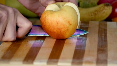 Man-is-cutting-an-apple-on-cutting-board-in-slow-motion