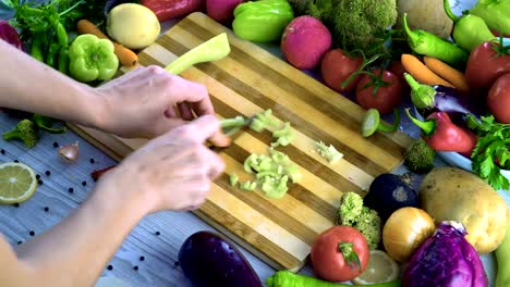 Man-is-cutting-vegetables-in-the-kitchen,-slicing-green-bell-pepper