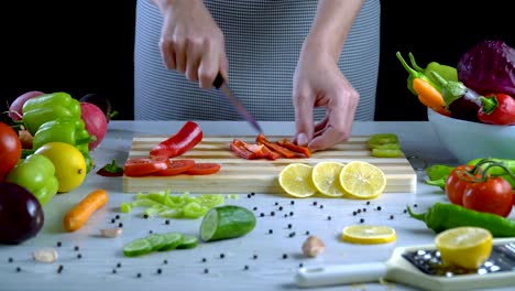 Man-is-cutting-vegetables-in-the-kitchen,-slicing-red-bell-pepper