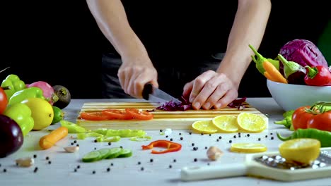 Man-is-cutting-vegetables-in-the-kitchen,-slicing-red-cabbage