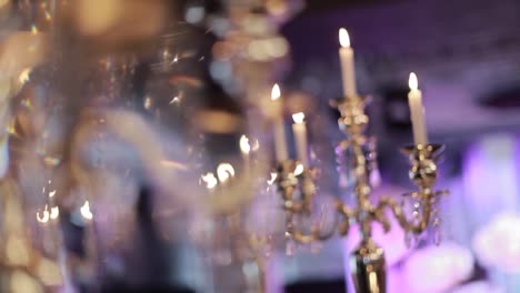 candles-burning-in-tall-glass-candlestick,-a-restaurant,-banquet,-decoration,-candles-at-the-wedding-table,-decorative-candles-are-lit-on-the-festive-table,-close-up