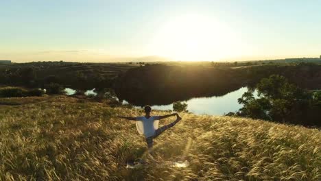 Girl-meditates-on-a-beautiful-meadow-at-sunset