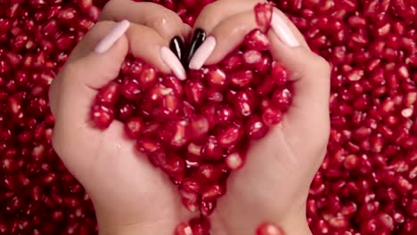 Falling-grains-of-pomegranate-into-the-hands-.-Slow-motion