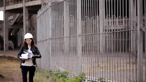 Chica-estudiante-inspecciona-el-sitio-de-construcción-para-hacer-correctamente-los-cálculos-para-el-proyecto-de-graduación