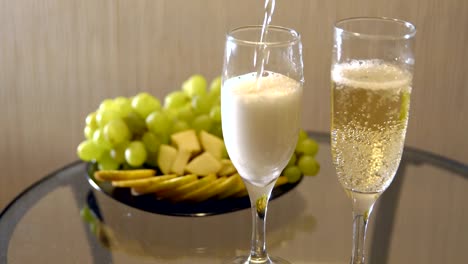 Romantic-date.-Spilling-champagne-in-glasses-on-a-table-with-fruit