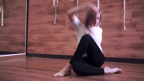 Young-girl-sitting-on-the-floor-doing-yoga