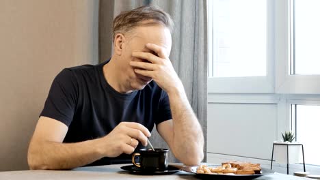 Hombre-adulto-en-la-mañana-en-la-cocina,-pensando-en-sus-problemas.-Él-está-bebiendo-café