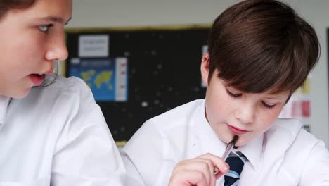 Male-And-Female-High-School-Students-Wearing-Uniform-Working-At-Desk-Together