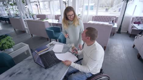 professional-education-of-handicapped-mature-male-in-wheelchair-with-teacher-women-using-smart-computer-technology-during-personal-lesson