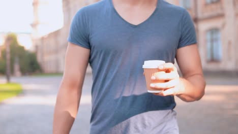 handsome-men-walks-drinking-tea-outdoors