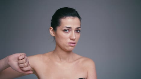 Mujer-joven-milennial-mostrando-un-signo-de-aversión,-aislado-sobre-un-fondo-gris