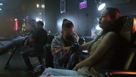 Man-Woman-Getting-Tattoo-in-Beauty-Salon-With-Artists-Working