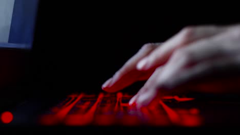 hacker-girl's-hand-typing-on-keyboard-with-red-backlight