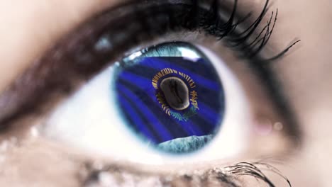 Woman-blue-eye-in-close-up-with-the-flag-of-Kentucky-state-in-iris,-united-states-of-america-with-wind-motion.-video-concept