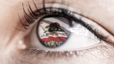 Mujer-ojo-verde-en-primer-plano-con-la-bandera-del-estado-de-California-en-iris,-estados-unidos-de-América-con-movimiento-de-viento.-concepto-de-vídeo