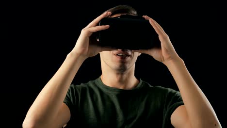 Gire-young-Man-probando-gafas-VR-en-fondo-negro.-Hombre-recibiendo-sorpresa-usando-casco-de-realidad-virtual-3D-Gaming-Innovation-Internet-Entertainment-Technology