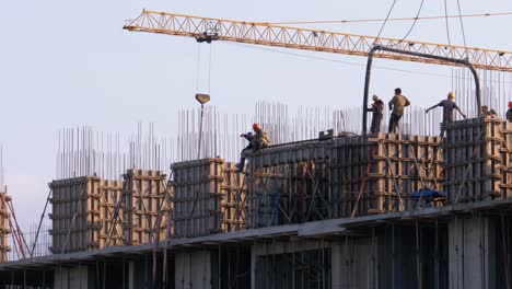 Workers-at-a-Construction-Site.-A-Crane-on-a-Construction-Site-Lifts-a-Load
