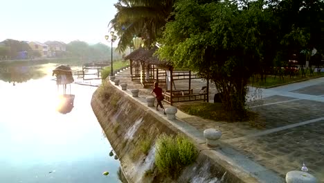 chica-delgada-hace-ejercicios-en-la-orilla-del-río-del-canal