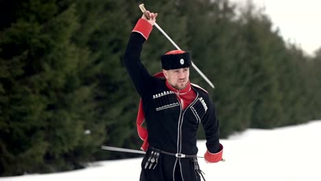 Ein-junger-Mann-in-Kosakenkleidung-schwingt-ein-Schwert-in-einer-Winterlandschaft-im-Schnee.