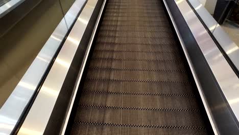 long-walkway-of-escalator-at-international-airport-terminal,-moving-POV