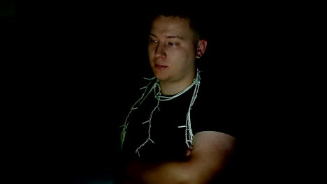 Sad-young-man-with-christmas-garland-using-computer