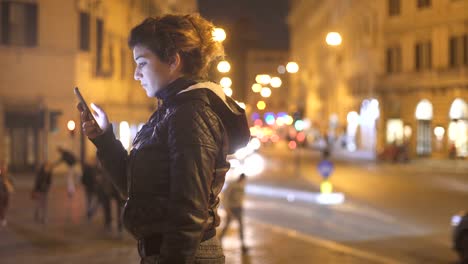 Serious-and-worried-woman-profile-typing-on-the-smartphone-at-night-in-the-city