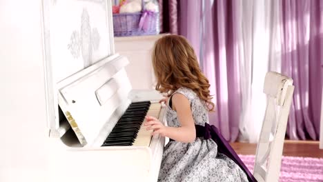 chica-rubia-juega-piano,-muchacha-en-un-vestido-con-un-cinturón-púrpura