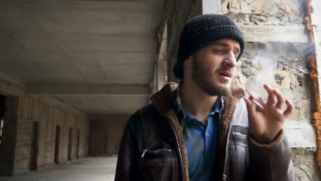 Homeless-man-smokes-cigarette-in-abandoned-building