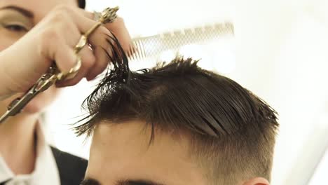 Woman-haircutter-combing-wet-hair-during-male-hairstyle-in-barbershop.-Professional-male-hairstyle-and-hairdressing-in-beauty-salon