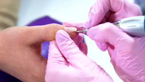 Beautician-careful-and-accurate-removing-cuticles-with-polish-machine