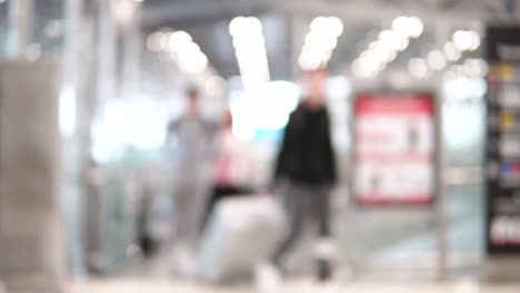 Unscharfe-Aufnahmen-von-Passagieren-im-internationalen-Flughafen-terminal-zu-Fuß.-4K-Video-mit-defokussierten-Wirkung.