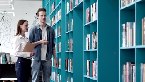 Fade-in-of-couple-standing-near-shelves-in-bookstore-and-choosing-book,-man-giving-advice-to-his-girlfriend