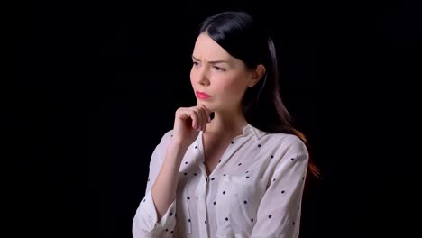 Pensive-young-brunette-woman-in-shirt-with-crossed-hands-thinking-and-standing-isolated-on-black-background