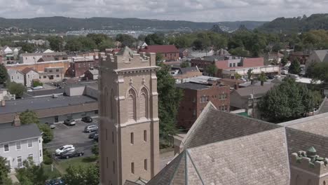 Slow-Forward-Aerial-Establishing-Shot-of-Church-Tower-in-Small-Town