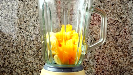 Filling-in-the-blender-of-a-kiwi,-oranges-and-bananas.	Preparation-of-smoothie-in-the-blender.