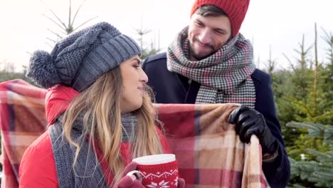 Couple-with-blanket-embracing-in-forest