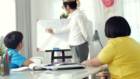 Tutor-room-children-in-class-writing-on-board-with-teacher.-4K-Slow-motion-Asian-child-learning-with-teacher-at-home.