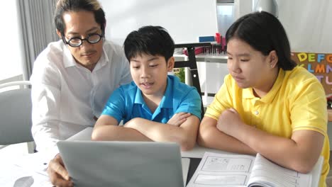 Tutor-room-children-in-class-learning-on-laptop-computer-with-teacher.-4K-Slow-motion-Asian-child-learning-with-teacher-at-home.