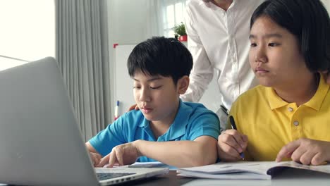 Tutor-room-children-in-class-learning-on-laptop-computer-with-teacher.-4K-Slow-motion-Asian-child-learning-with-teacher-at-home.