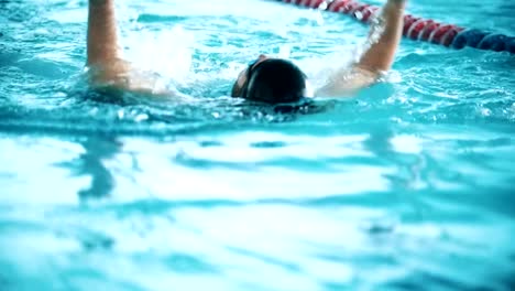 Behinderte-Mensch-schwimmt-auf-der-Rückseite-in-einem-Schwimmbad.-Slow-motion