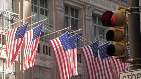 Tiro-iconic-de-la-ciudad-de-Nueva-York-con-bandera-americana,-semáforo-de-edificios