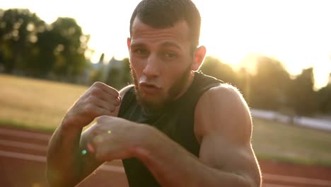 Aktive,-wütend-männlicher-Boxer-Trainingsprozess-auf-dem-Natur-Stadion.-Porträt-eines-Mannes-mit-unsichtbaren-Gegner-Boxen,-Stanzen